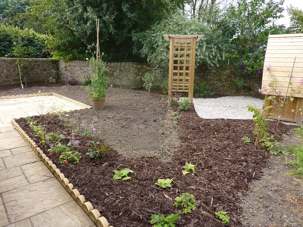 Fresh bark mulch spread across new garden beds